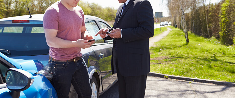 Two male drivers exchanging information after a minor crash