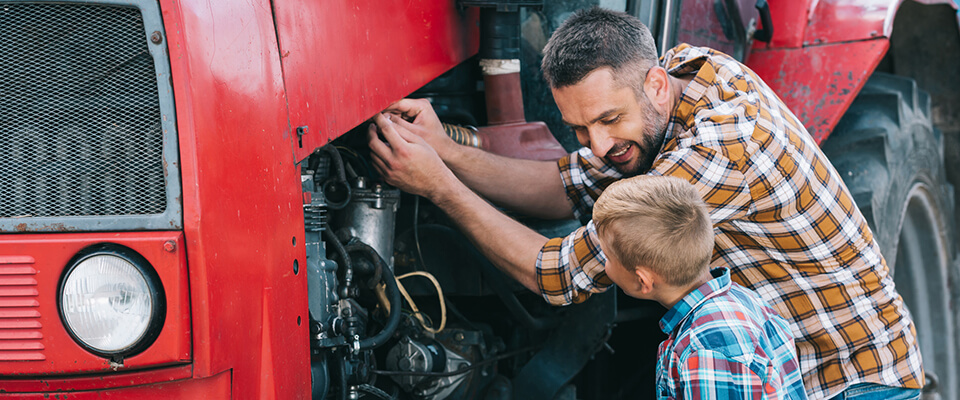 Father and son repairing tractor